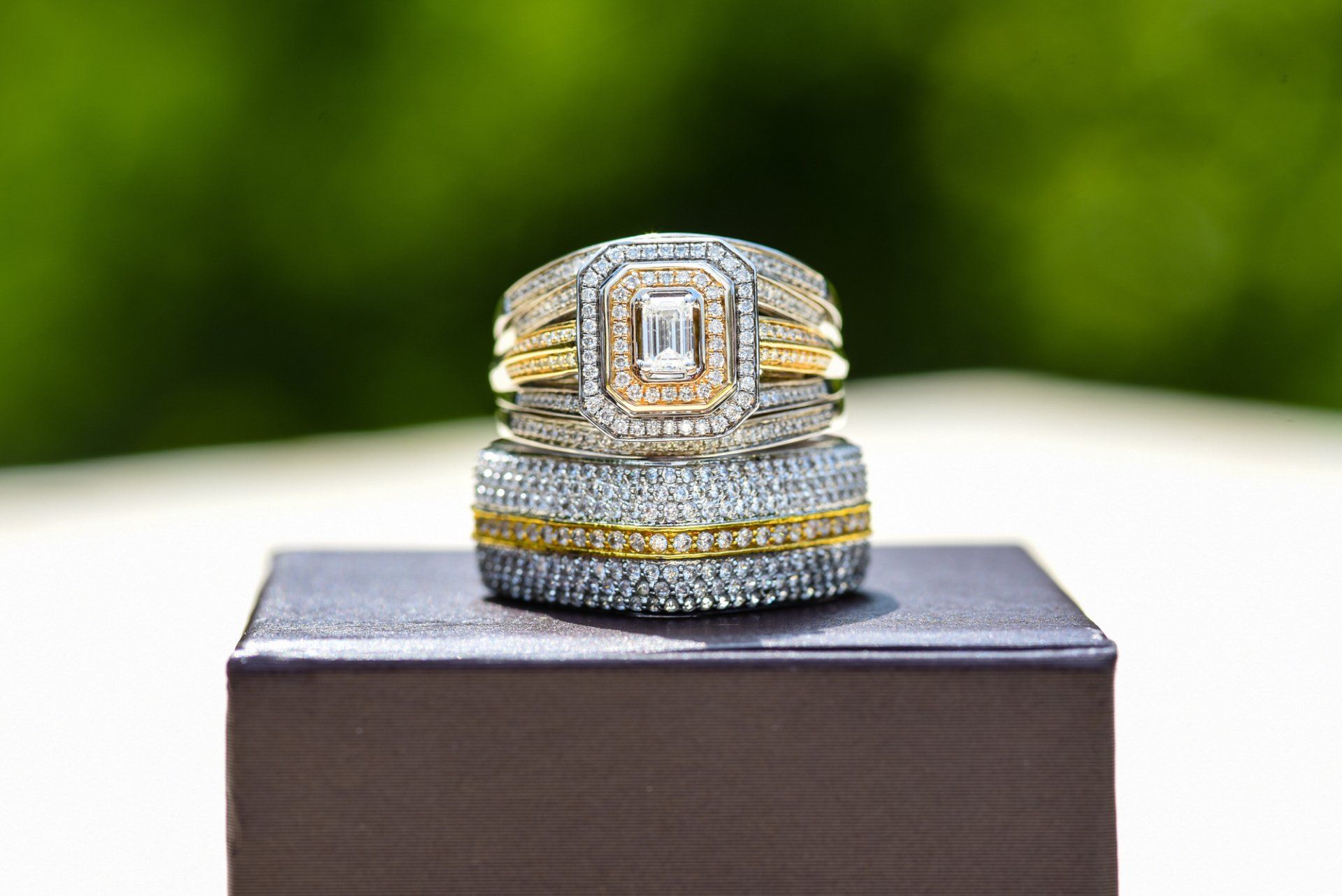 a couple of wedding rings stacked on top of each other on a box .