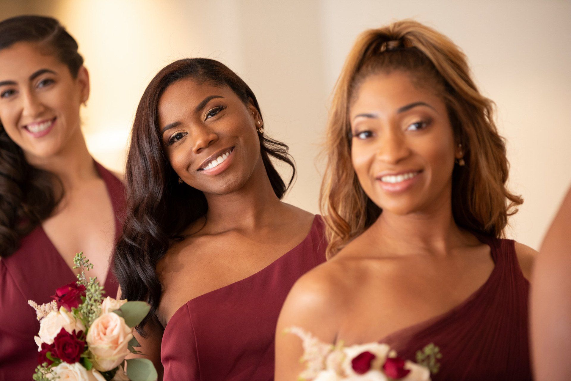 a group of bridesmaids are standing next to each other and smiling .
