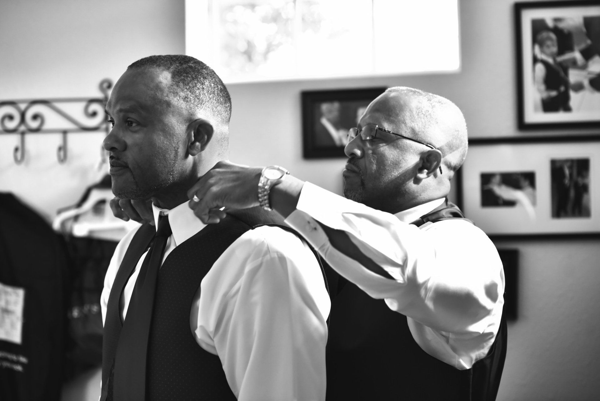 a black and white photo of two men getting ready for a wedding