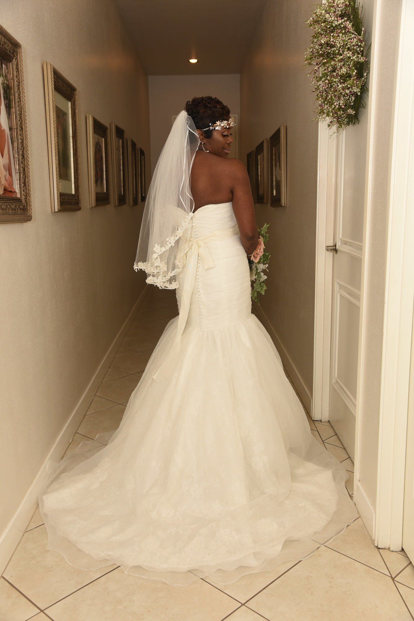 a woman in a wedding dress is standing in a hallway