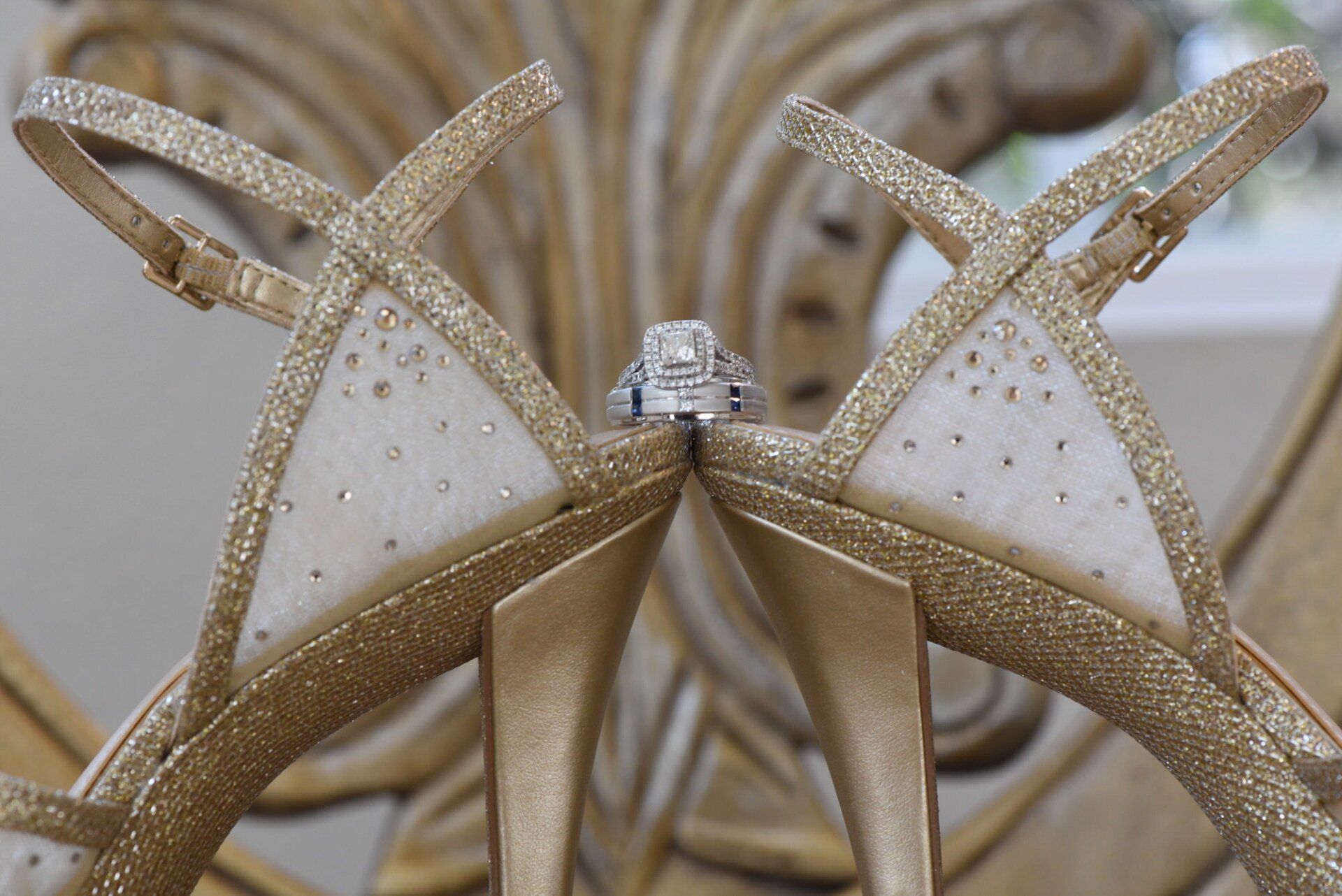 a pair of gold shoes with a diamond ring on them