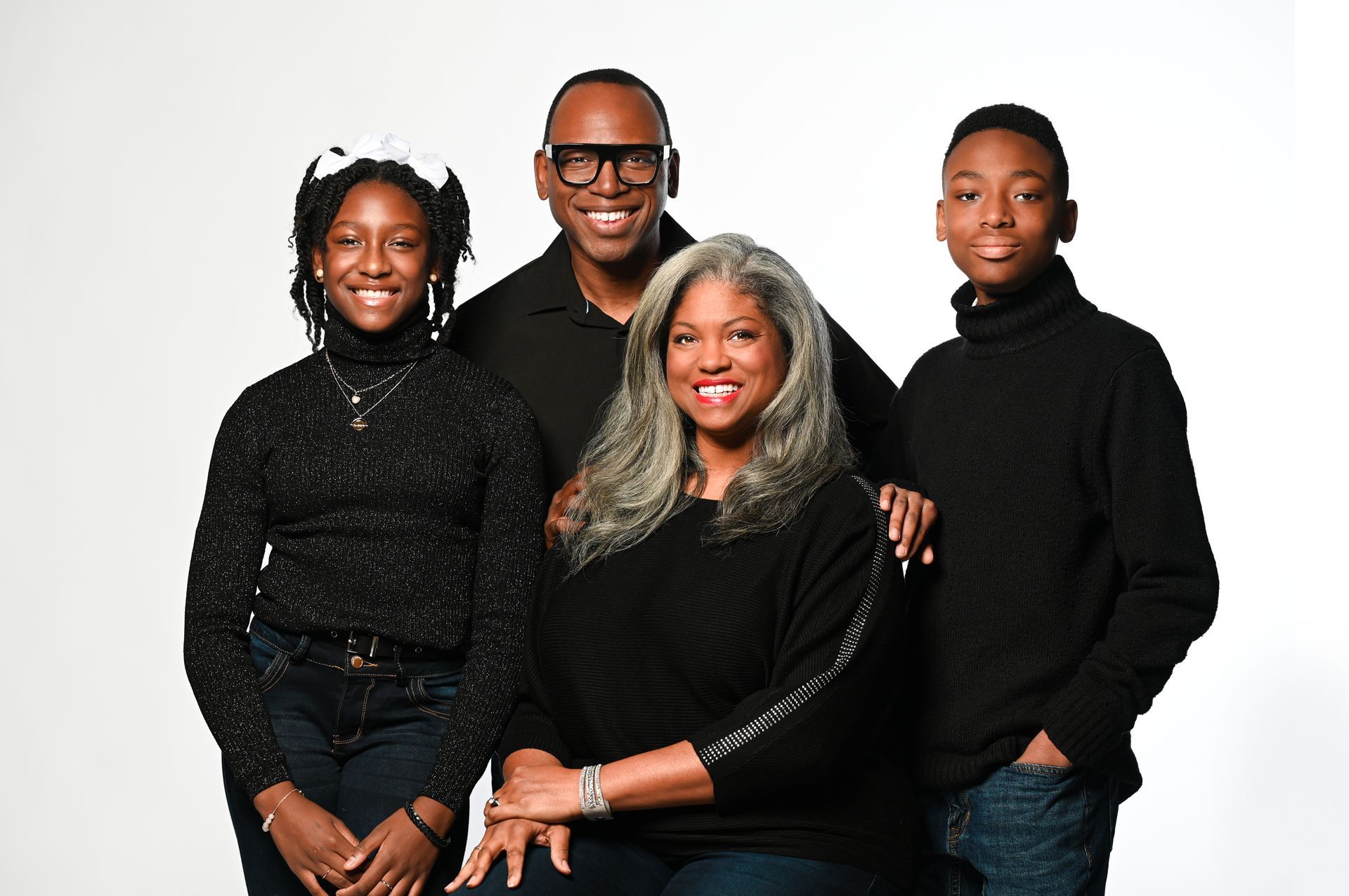 a family is posing for a picture together while wearing black sweaters .