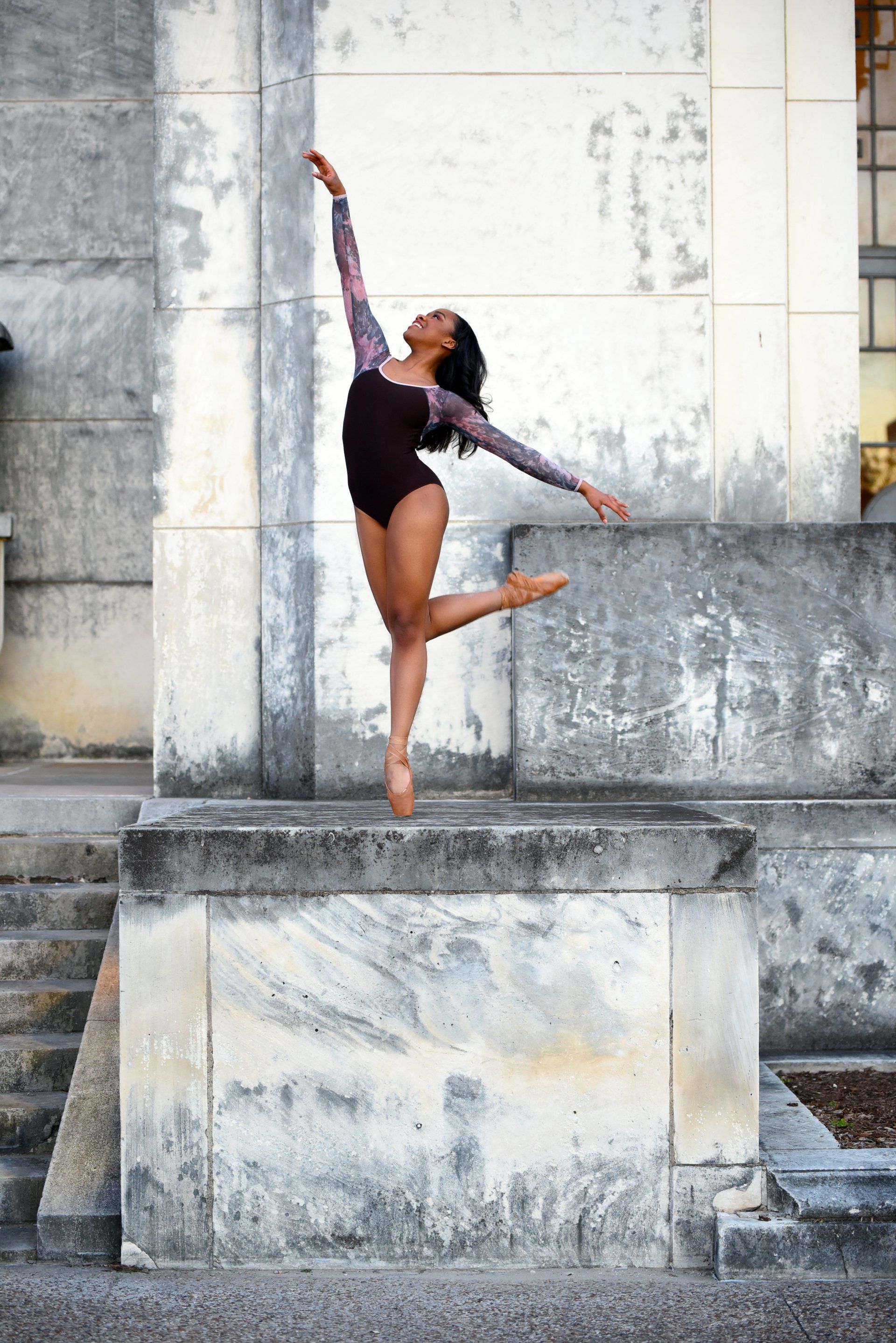 a ballerina is jumping in the air in front of a building .