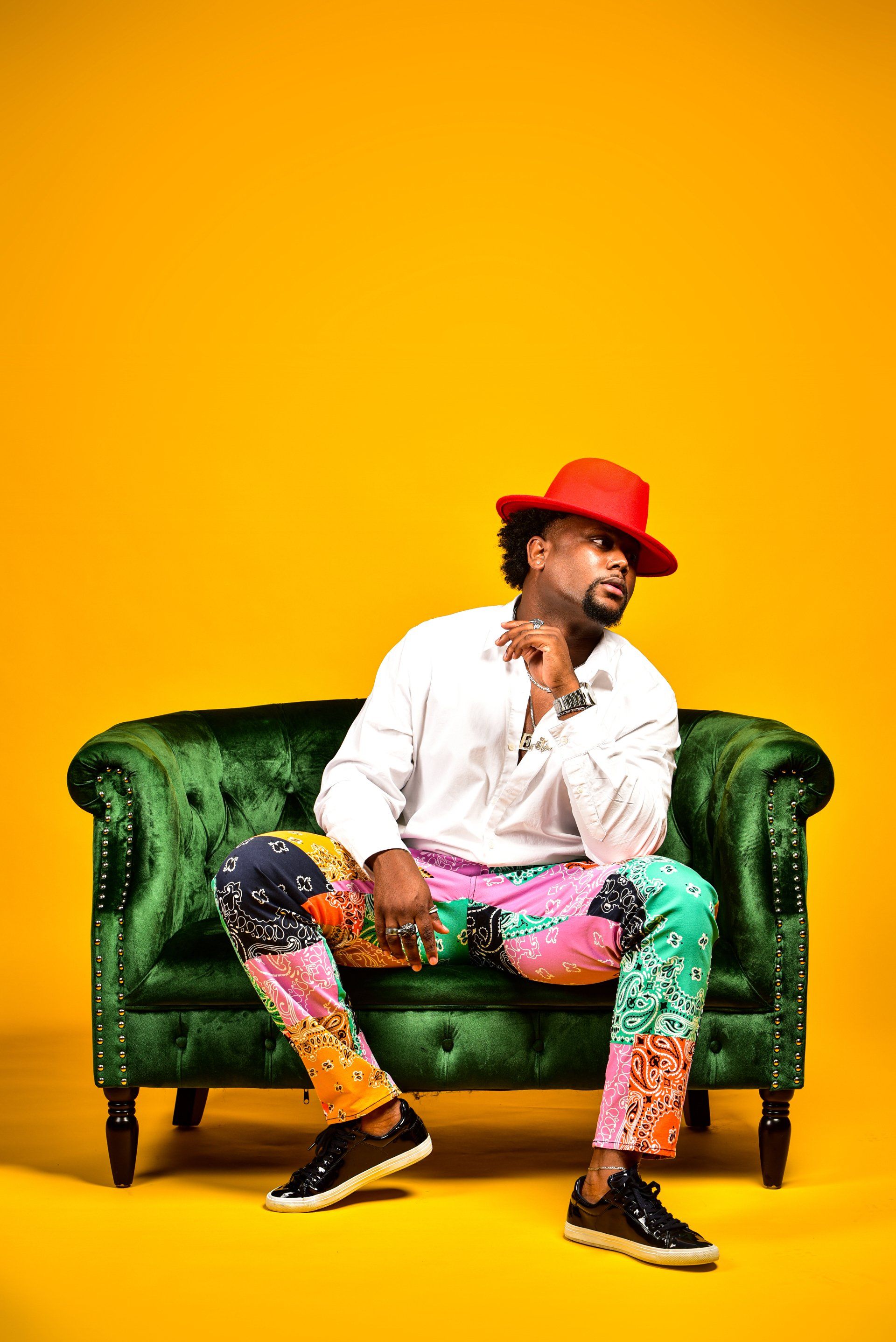 a man in a red hat is sitting on a green couch .