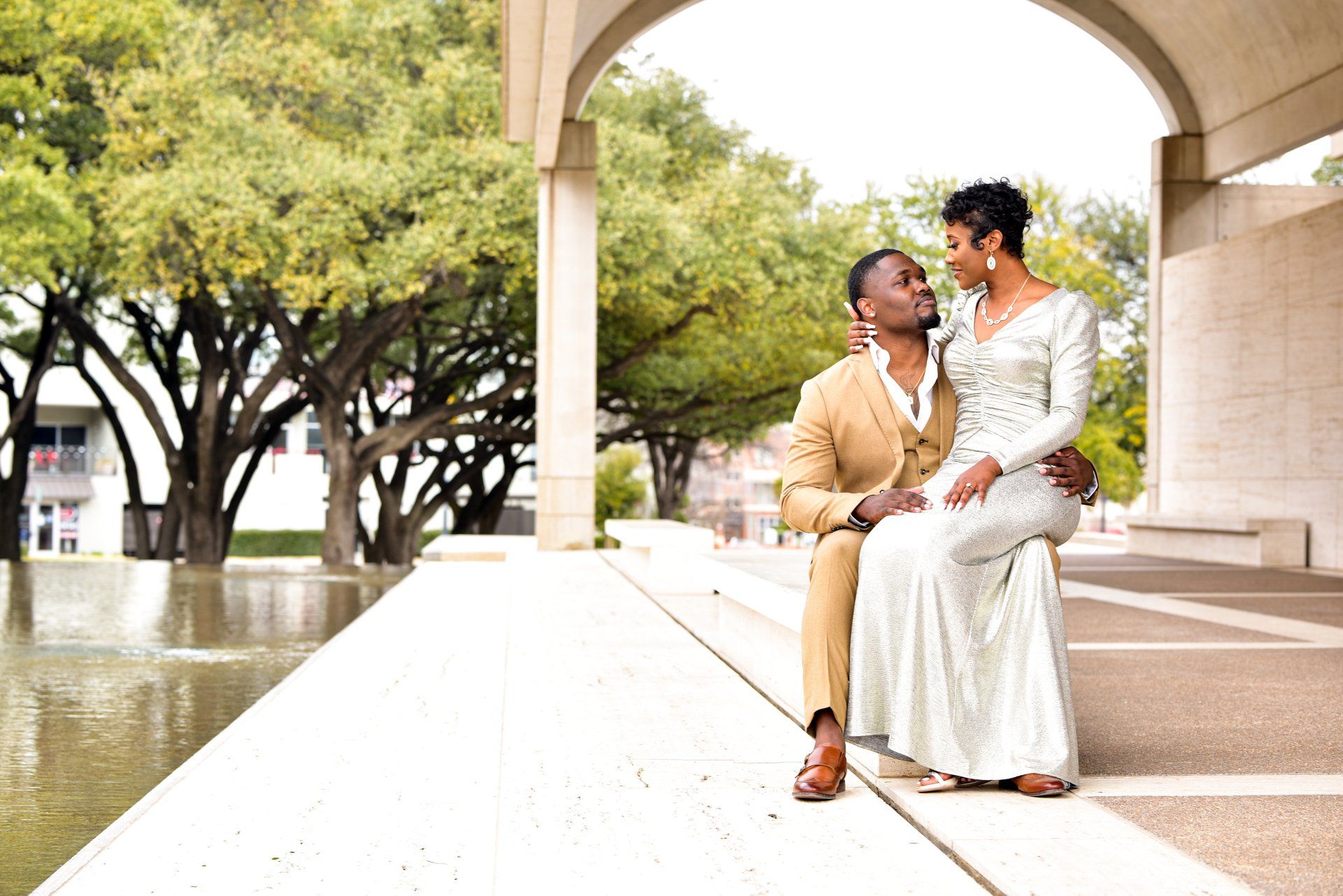 a man and a woman are sitting next to each other on a sidewalk .