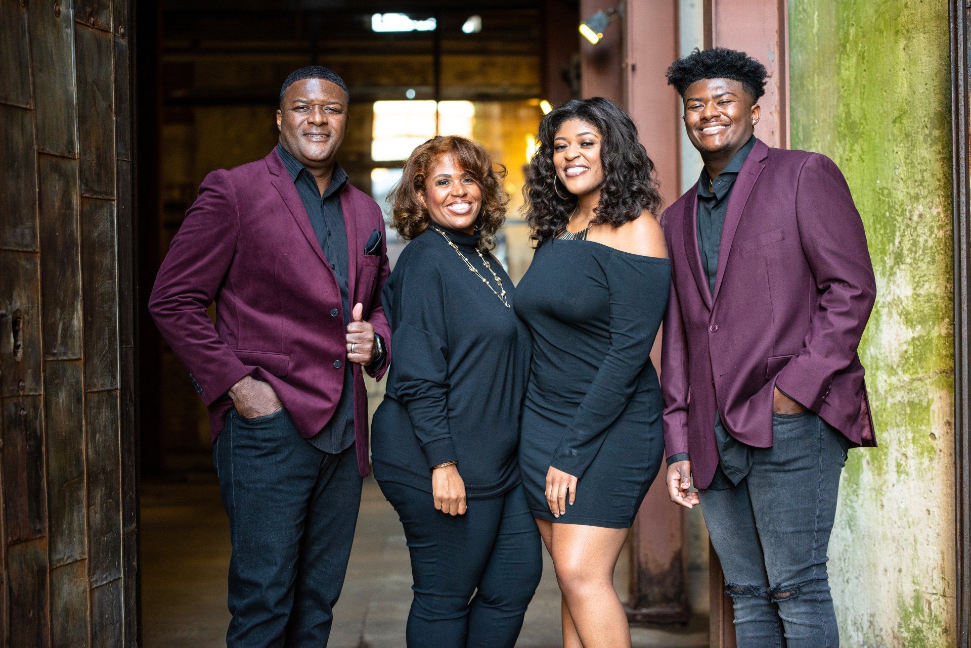 a family is posing for a picture in front of a building .