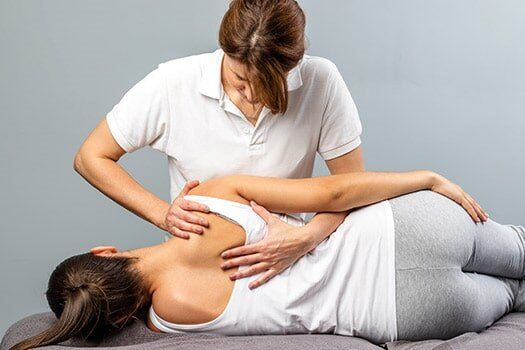 Female Therapist Manipulating Shoulder Blade - Chiropractic Services in Anderson, SC
