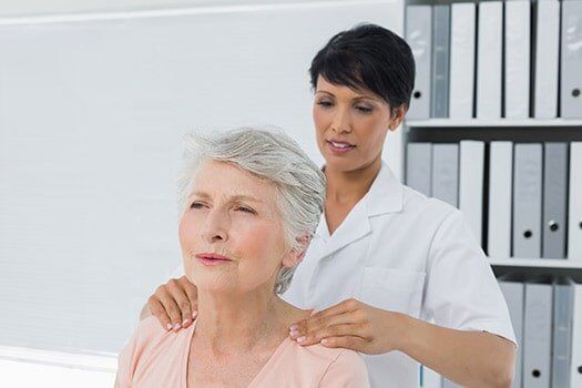 Chiropractor Massaging A Senior Woman's Shoulder - Chiropractic Services in Anderson, SC