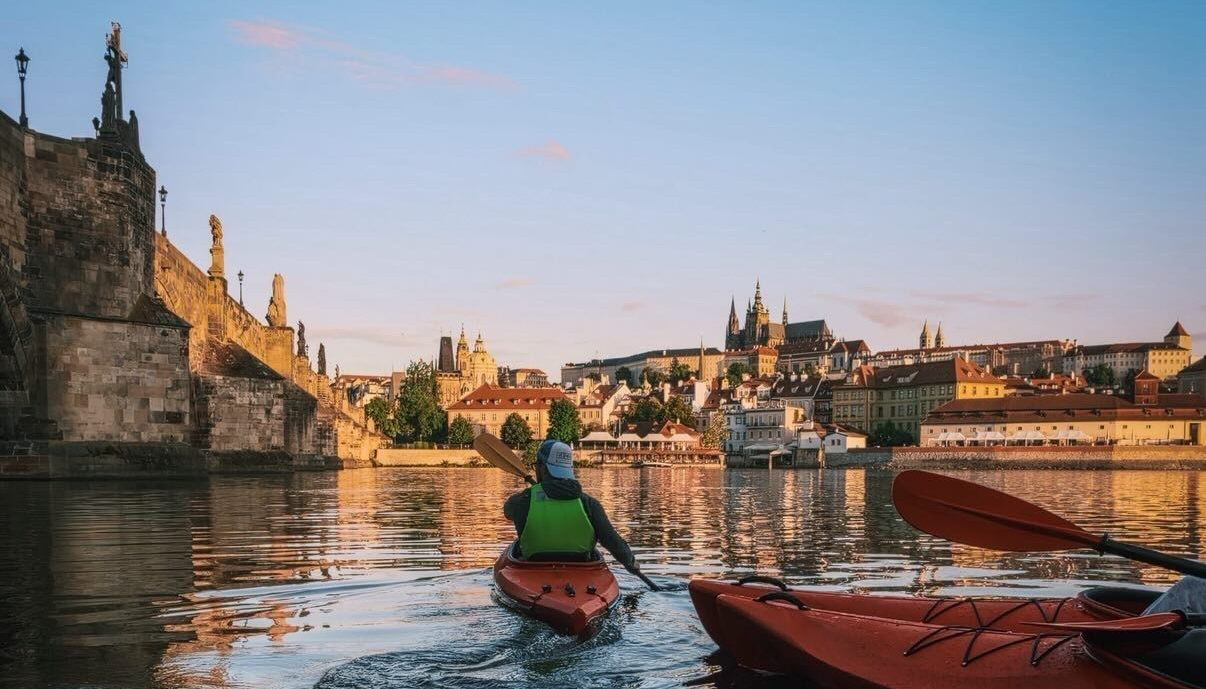Kayakers paddling beneath Charles Bridge during a sunrise tour in Prague