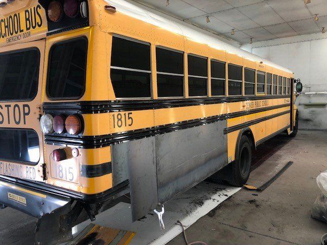 A yellow school bus is parked in a garage.