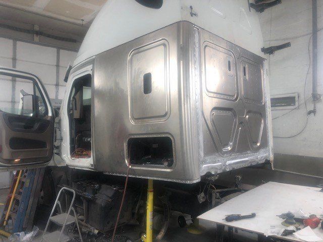 A truck cab is being built in a garage.