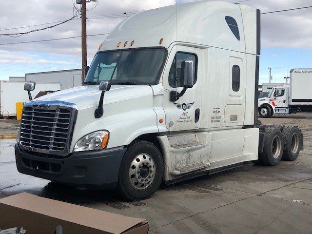 A white semi truck is parked in a parking lot.