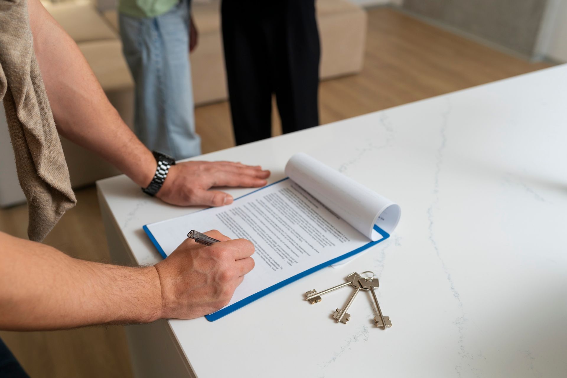 A man is signing a document on a clipboard.
