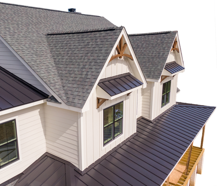 White house with gray shingle and dark metal roofs, windows, and wooden trim.