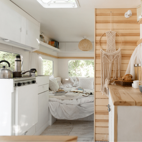 A kitchen with a bed and a dream catcher on the wall