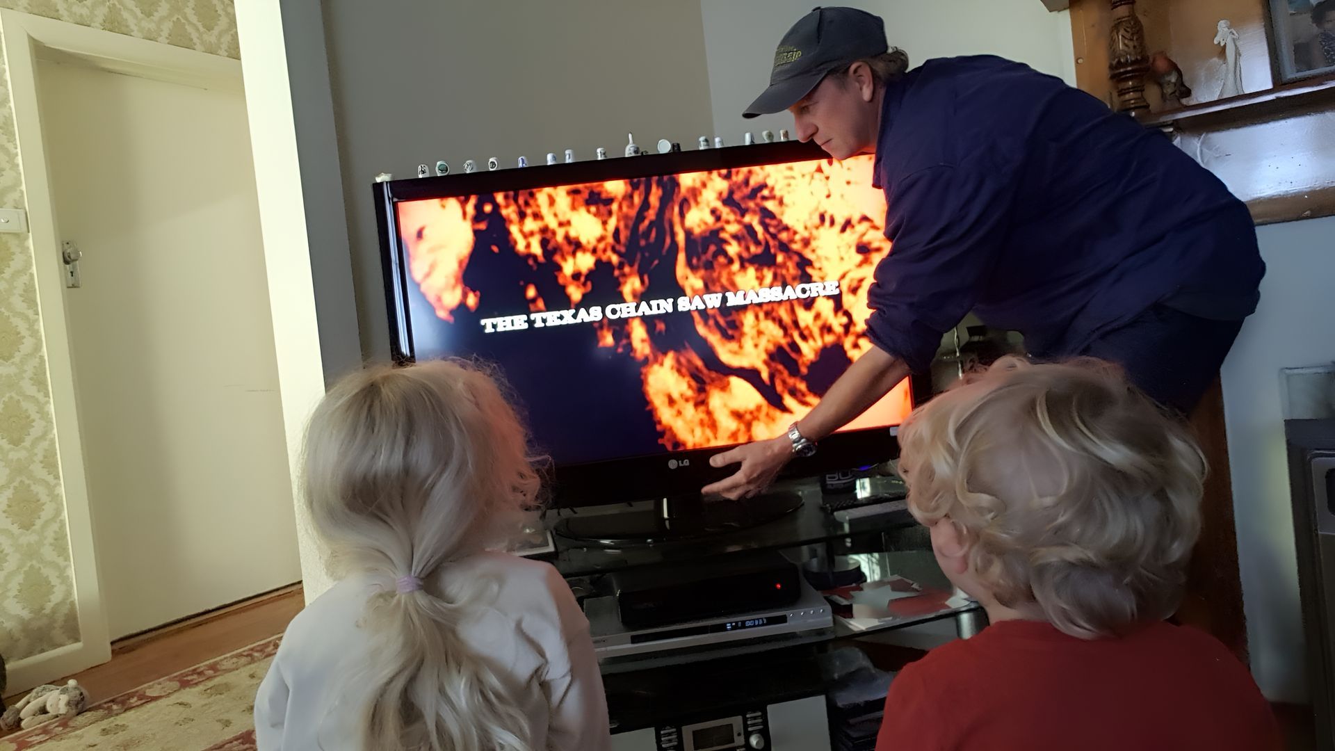 A Man And Two Girls Are Watching A Movie On A Flat Screen Tv — Craig's TV/Antenna Services In Cessnock, NSW