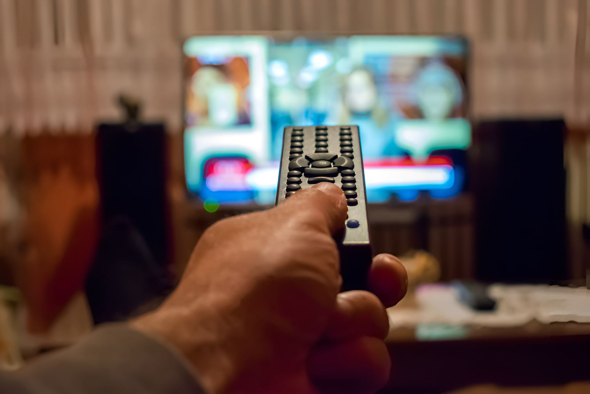 A Person Is Holding A Remote Control In Front Of A Television —  Craig's TV/Antenna Services In Maryland, NSW