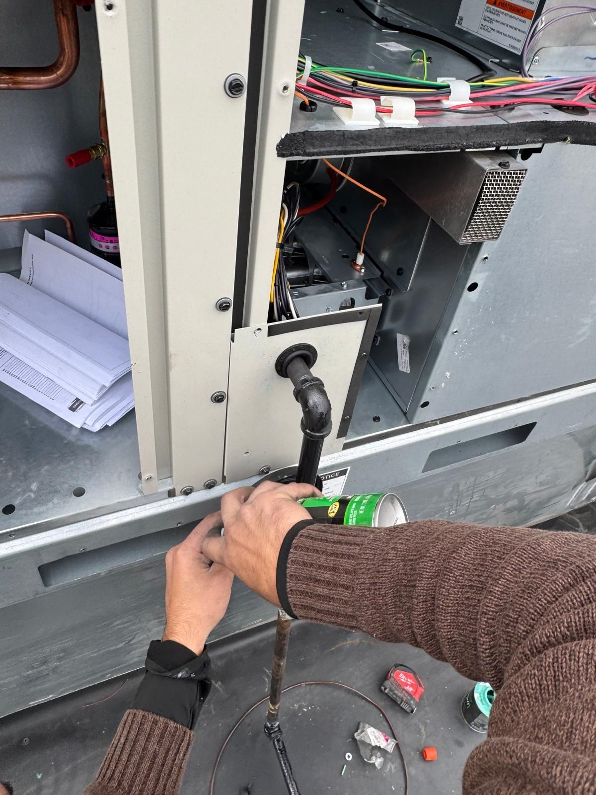 Woman in straw hat smiles, holding wine glass near a lake.