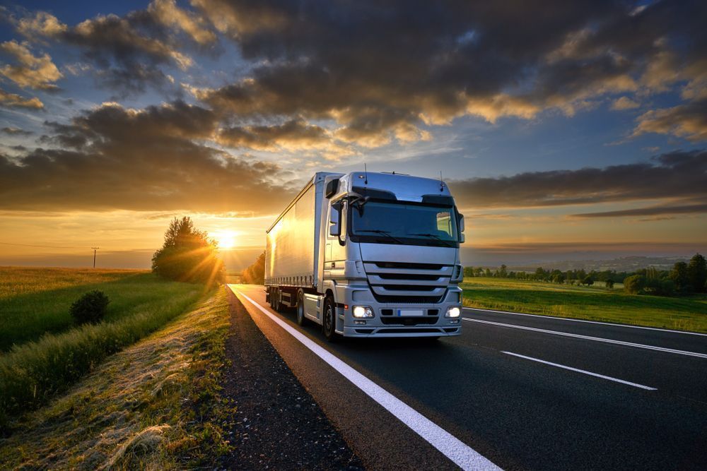 A Semi-Truck Driving on A Road at Sunset — Aust. Advanced Trailer Sales & Service in Berrimah, NT
