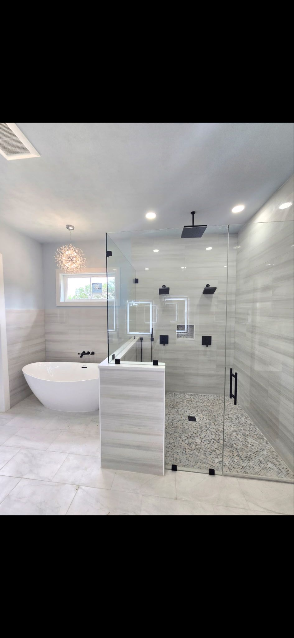 A concrete pathway and steps lead to a light gray house with a porch and dark brown door.