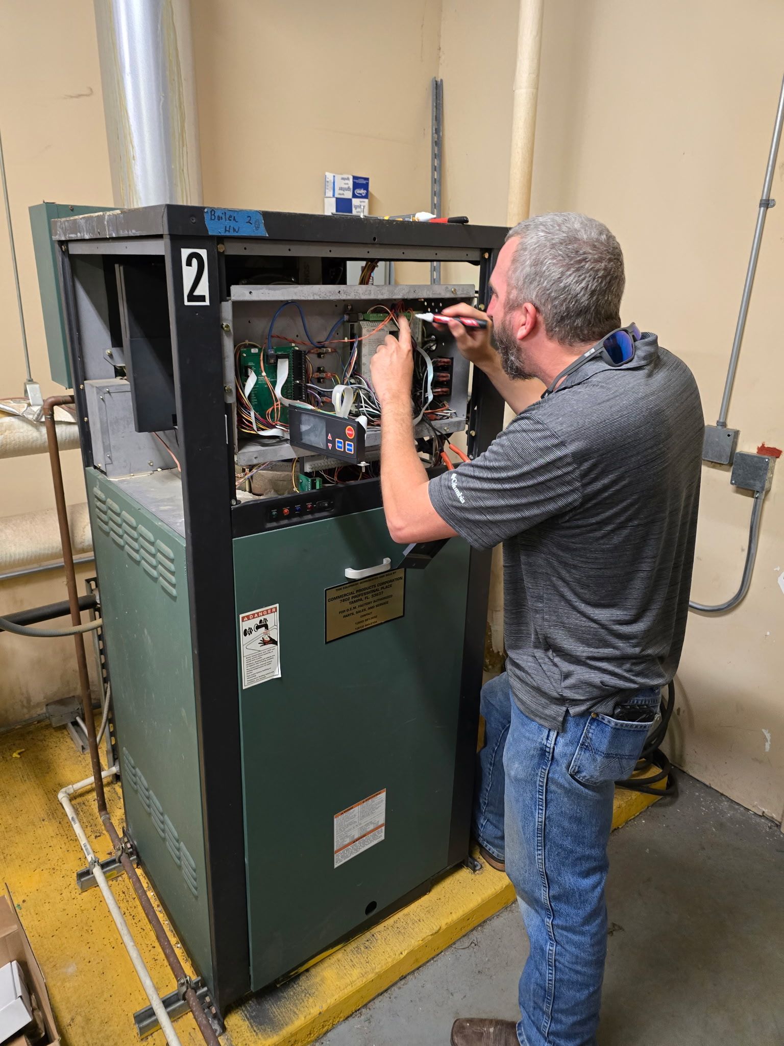 Several white vans with company logos parked on a grassy area next to a street. Trees and overcast sky in the background.