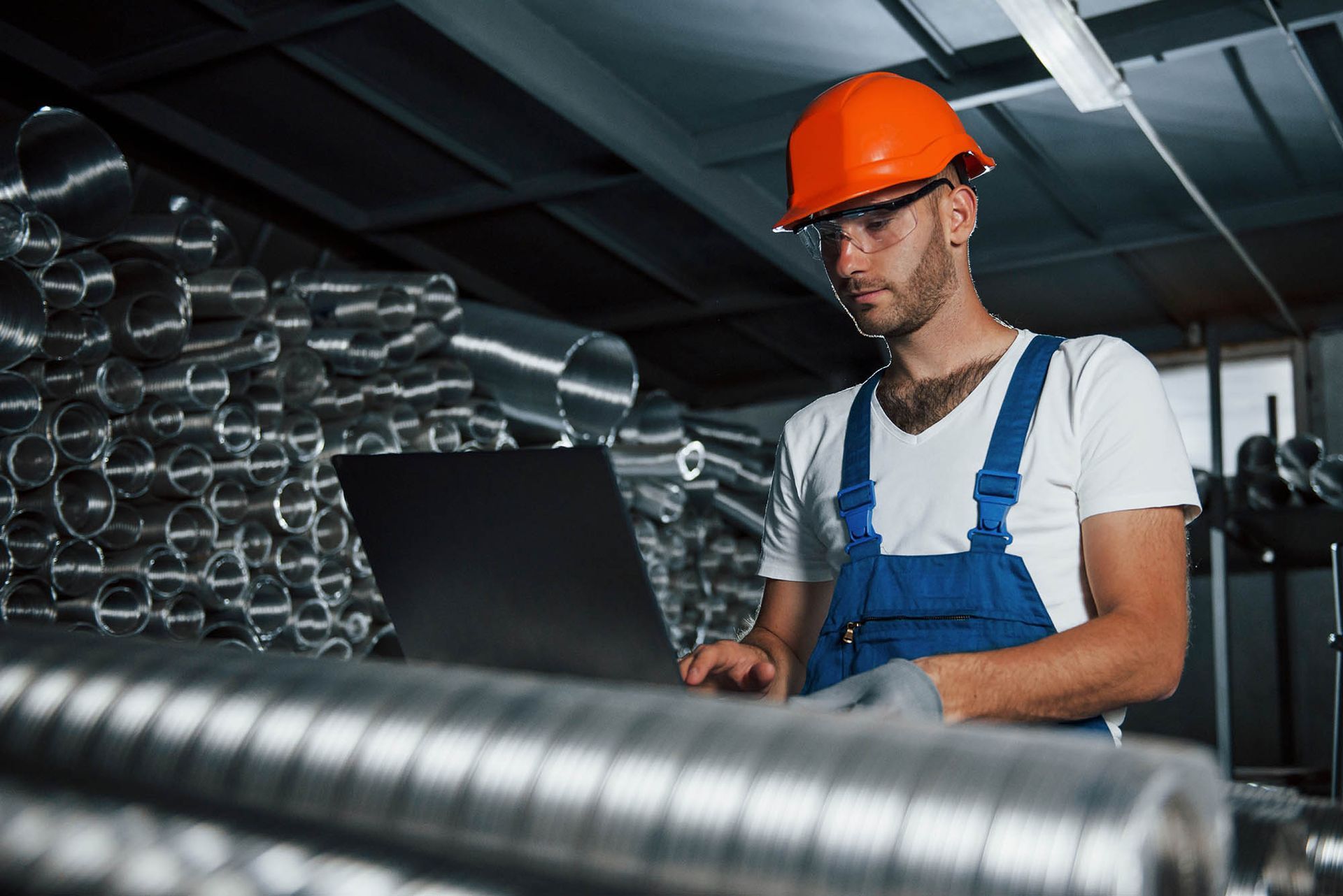 An inventory specialist manages stock on a laptop for a leading wholesale metal supplier. An inventory specialist manages stock on a laptop for a leading wholesale metal supplier.