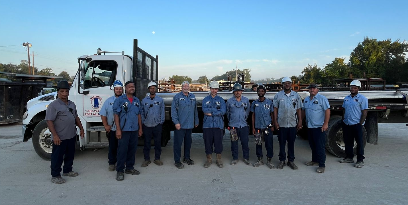 A large group of people in red shirts are standing in a warehouse.
