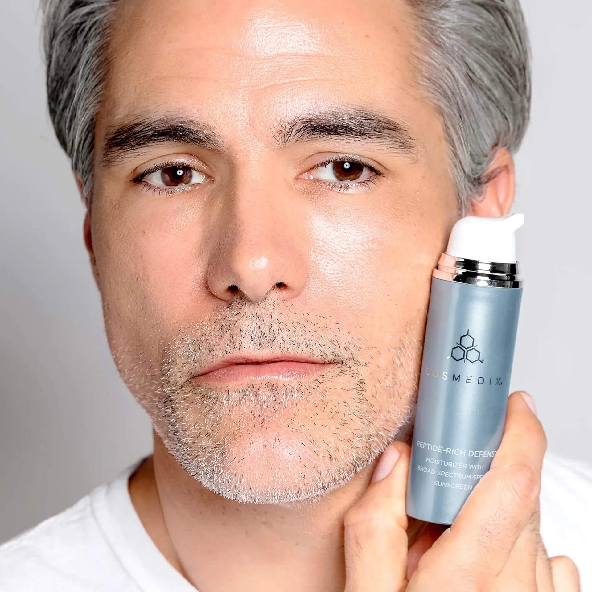 Men's image of natural skin with sunscreen in hand