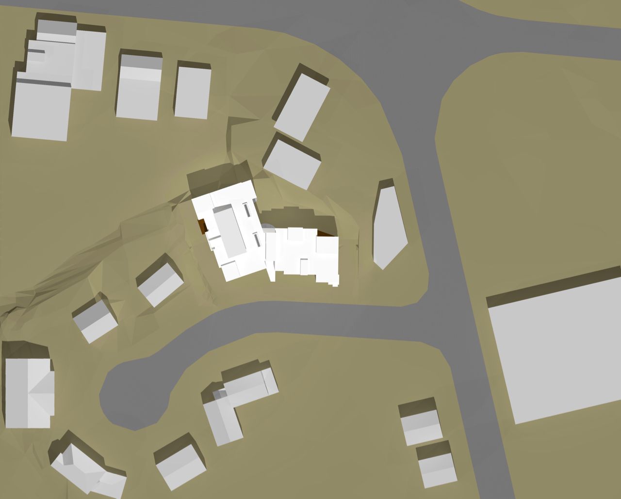 Overhead view of several buildings on a beige landscape with gray roads, including a highlighted, light-colored building.