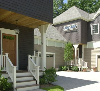 Two-story home with dark brown siding, tan trim, and a concrete driveway.