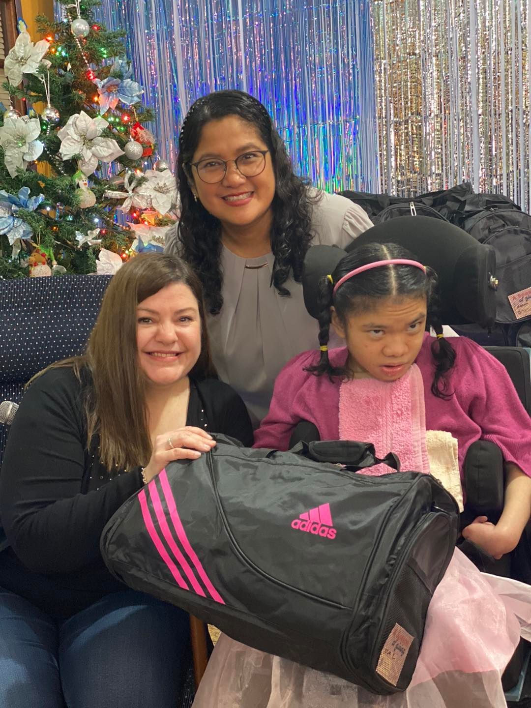 Woman with arms raised in a crowd, likely at a concert or church service with stage lights in the background.