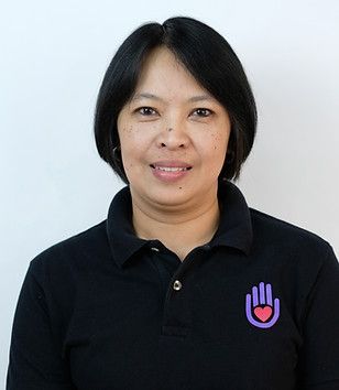Person playing an acoustic guitar, fingers on frets. Red and green stage lighting.