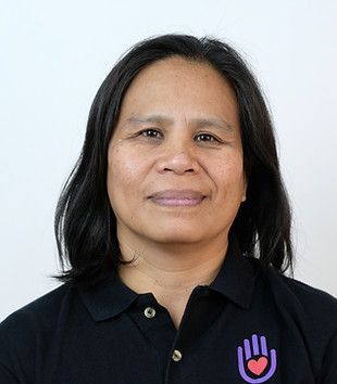 Woman embracing a person with a disability outdoors, both smiling.