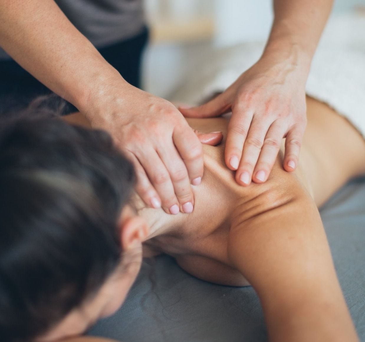 Two hands massaging human back