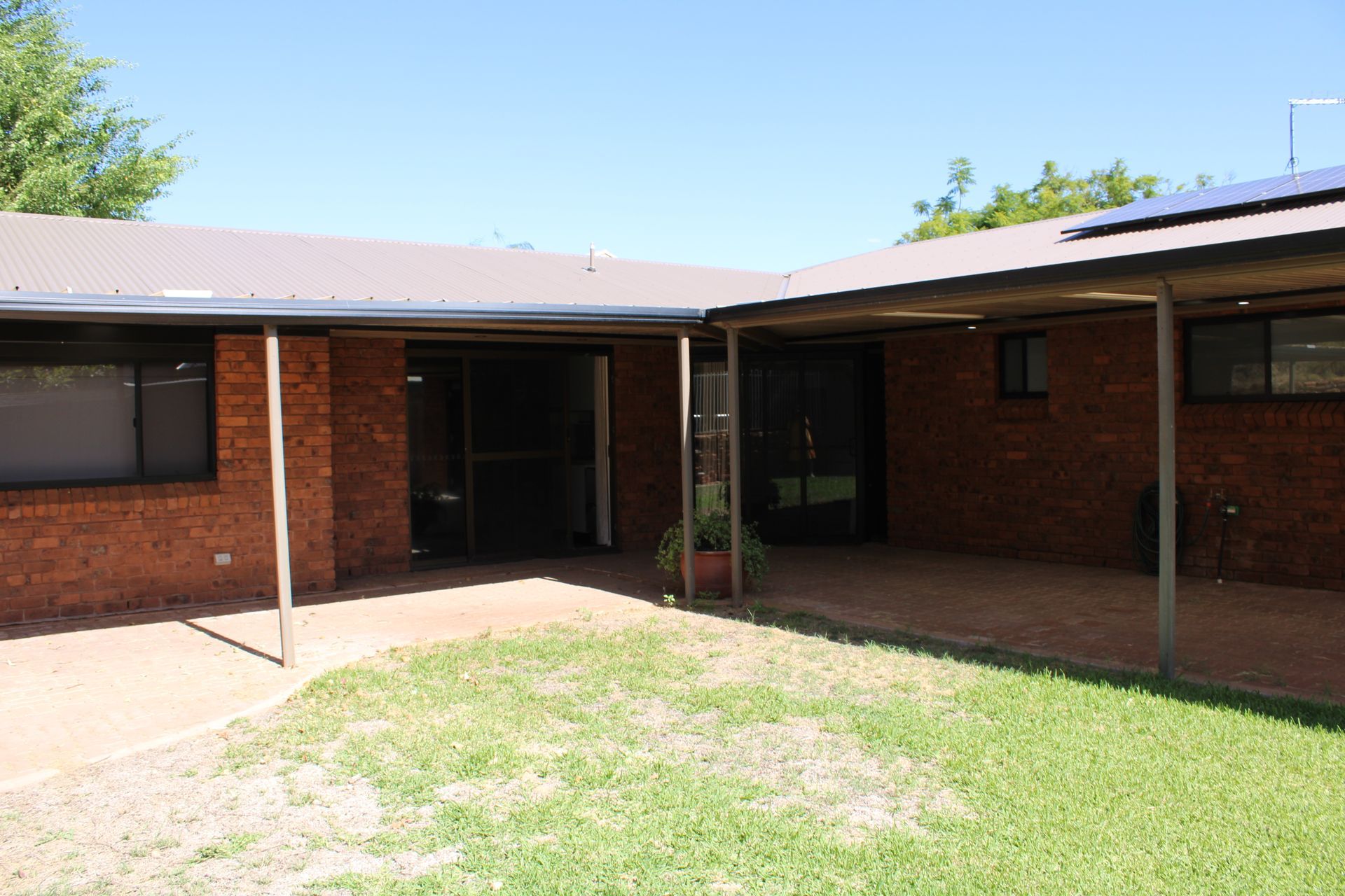 A brick house with a covered porch and a lawn in front of it