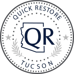 The logo for quick restore tucson is a seal with a face on it.