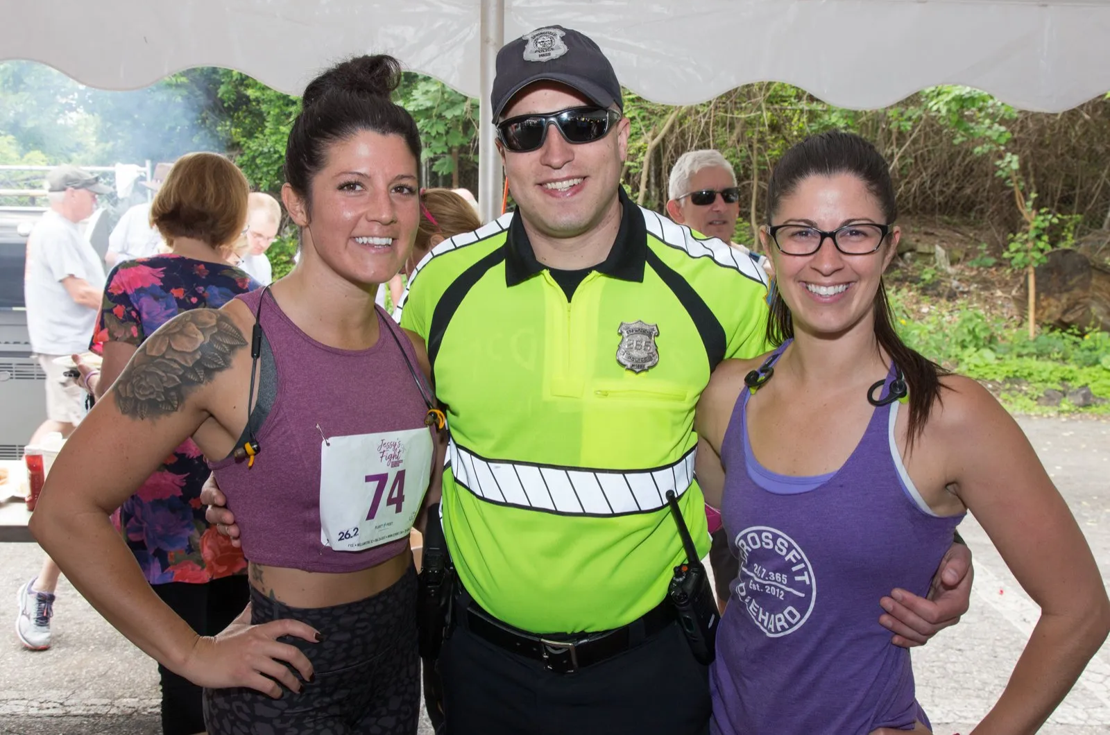 A man in a yellow shirt is posing for a picture with two women.