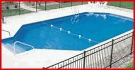 A large swimming pool surrounded by a metal fence.