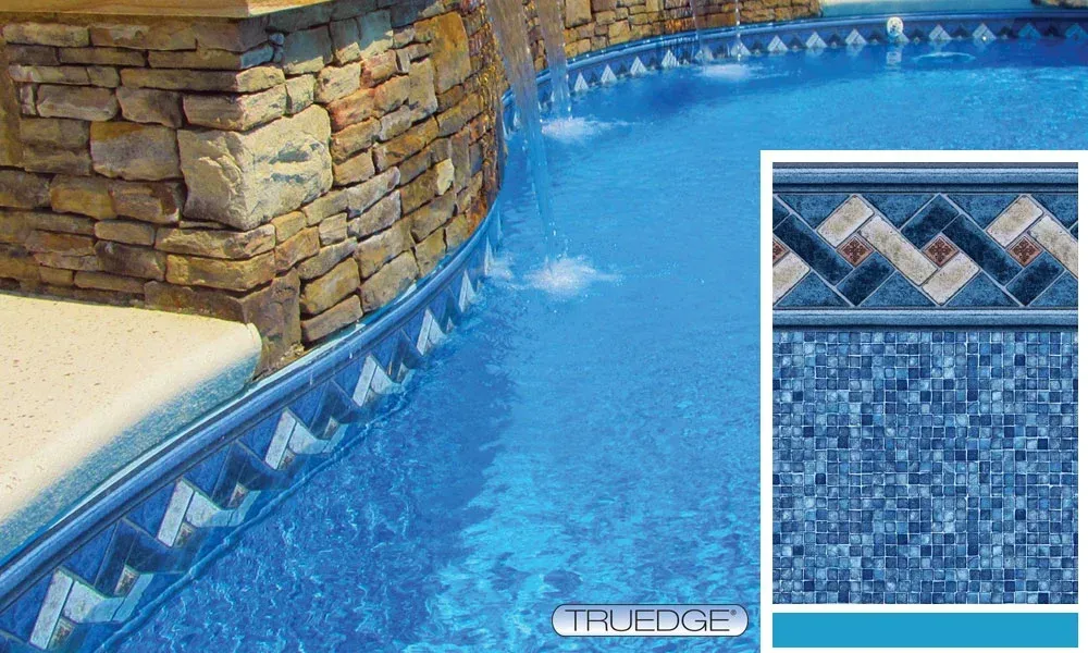 A swimming pool with a stone wall and a tile border