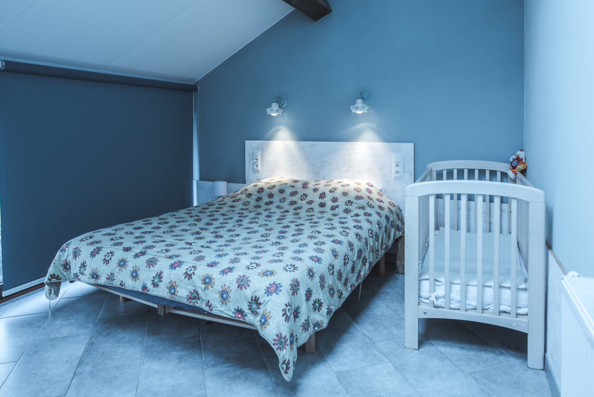 Une chambre avec un grand lit et un petit berceau