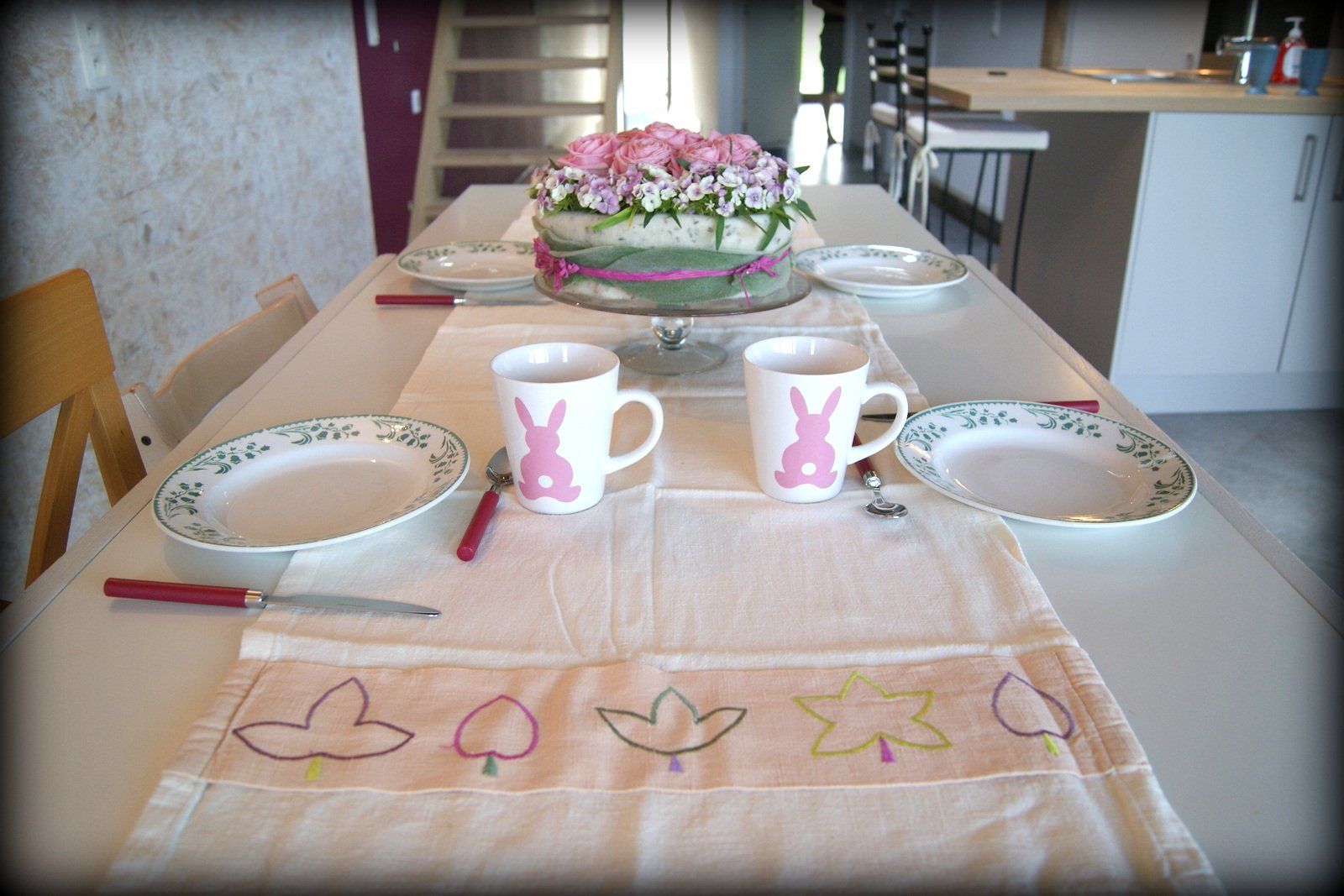 Une table avec des assiettes, des tasses et un gâteau dessus