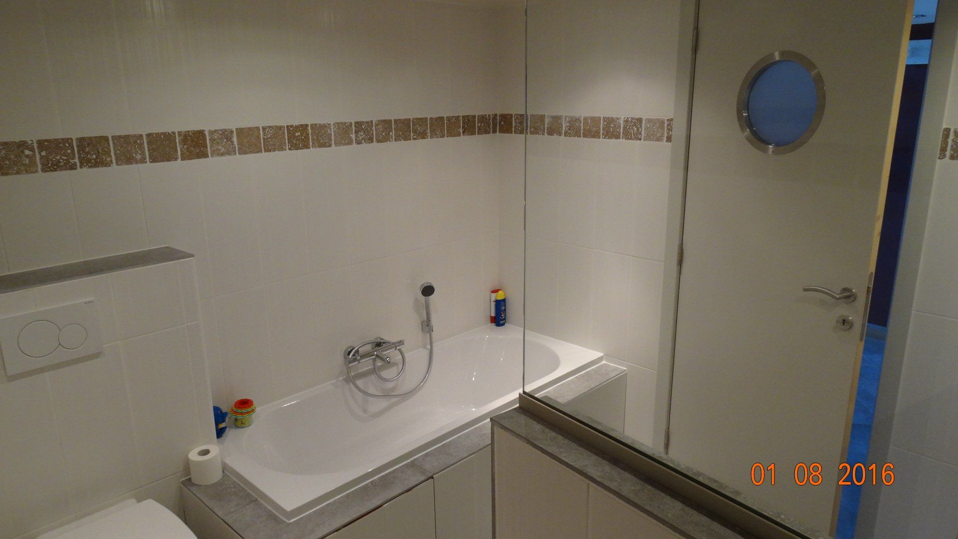 Une salle de bain avec baignoire et WC avec une photo prise en 2014