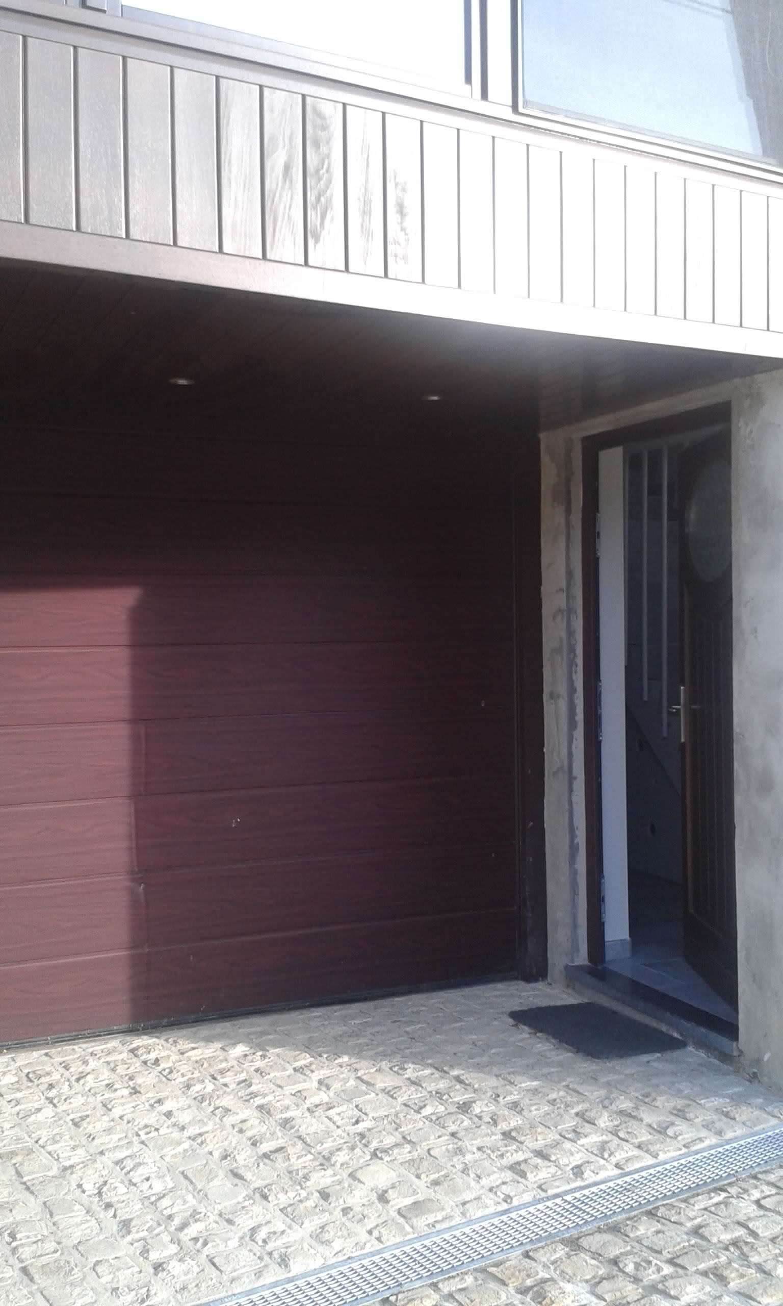 Une porte de garage marron se trouve à côté d'une porte blanche.