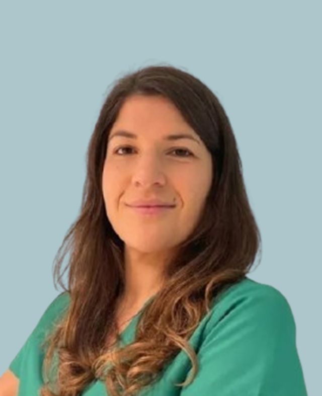 Una donna con una camicetta verde e le braccia incrociate