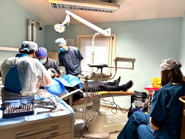 Un gruppo di dentisti sta lavorando su un paziente in una sala operatoria