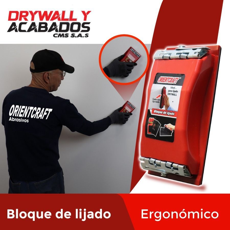 Hombre lijando paneles de yeso con un taco de lijado rojo. 