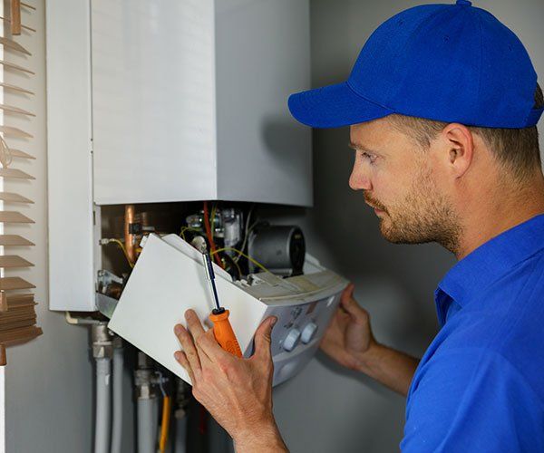 Man Fixing Heater — Green Valley, IL — Derek Bell Plumbing