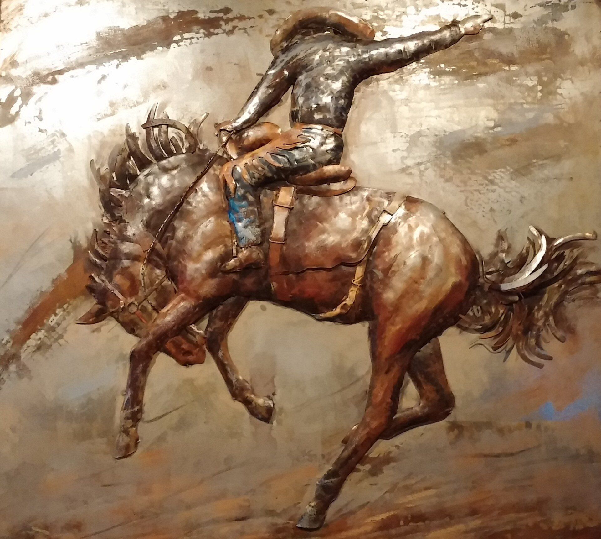 Cowboy riding a bucking bronco, bronze sculpture.