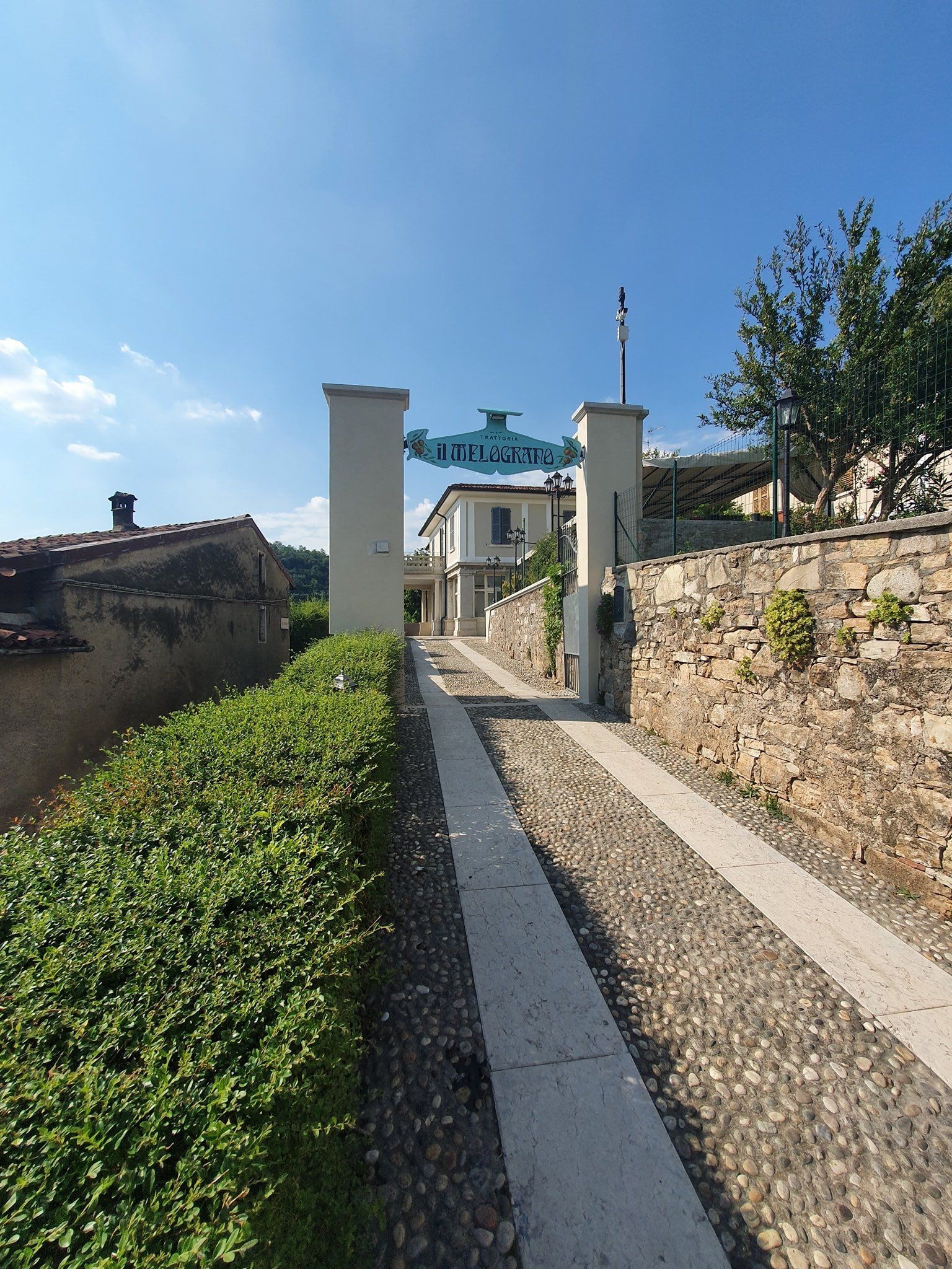 insegna di trattoria e sentiero in ciottoli