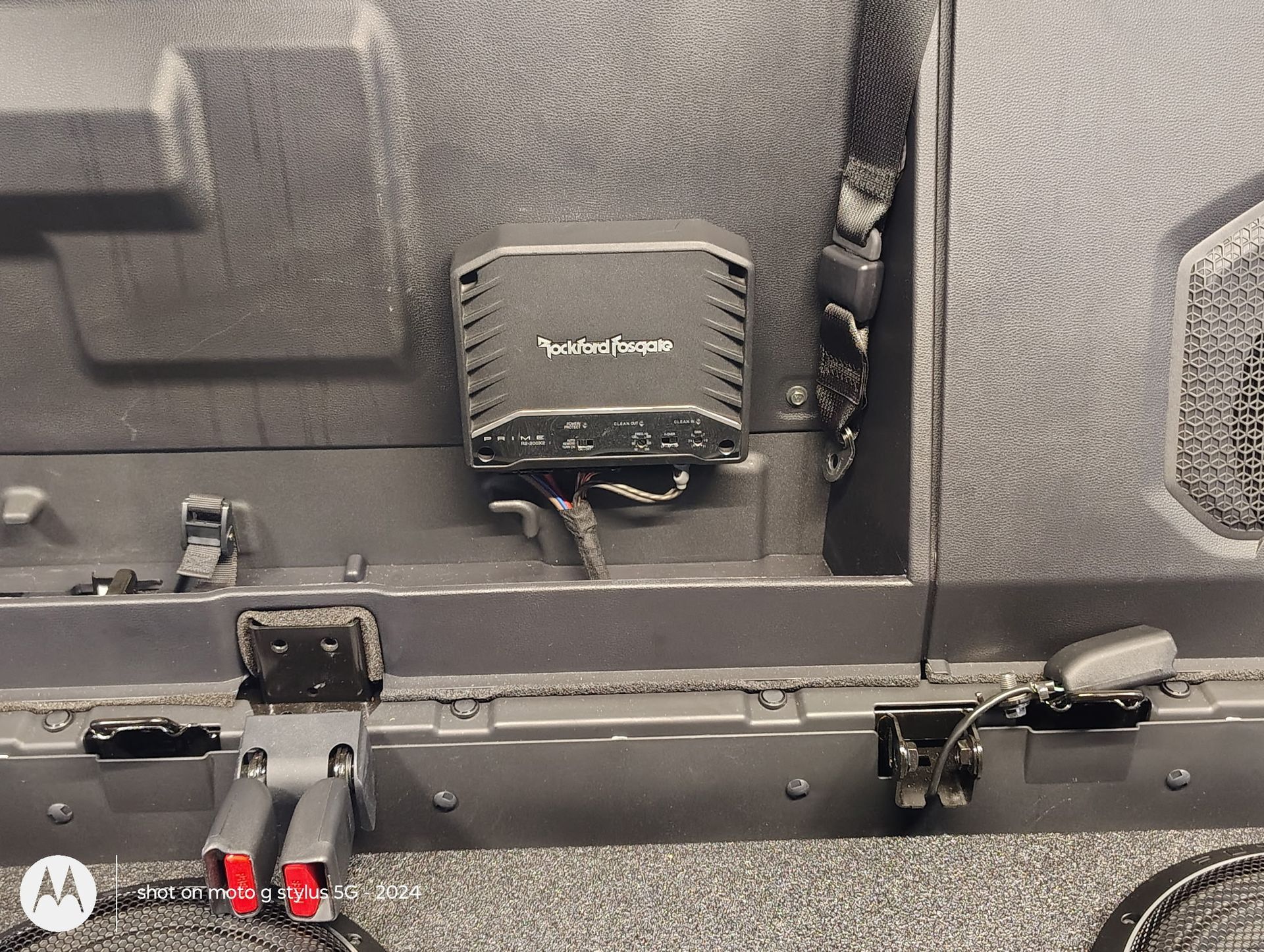 Black vehicle interior with a Rockford Fosgate amplifier mounted on the wall.